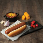 hot-dog-with-chile-on-wood-background.