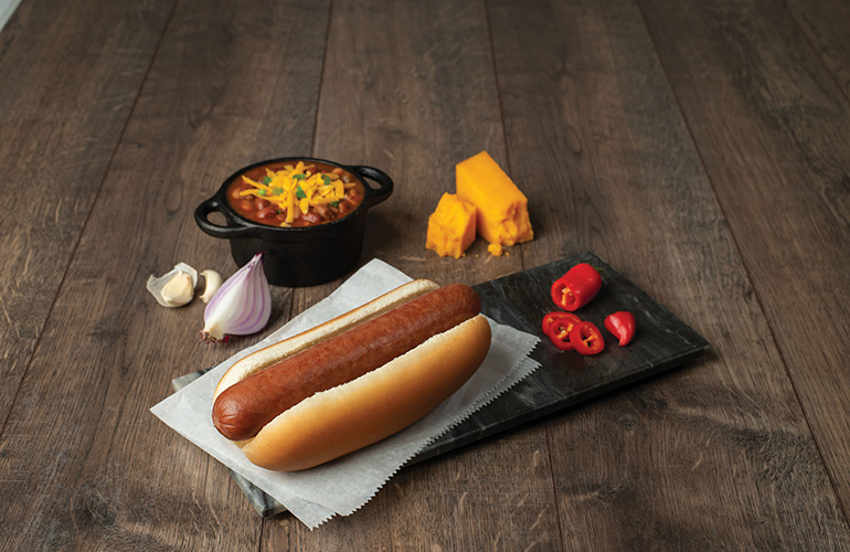 hot-dog-with-chile-on-wood-background.